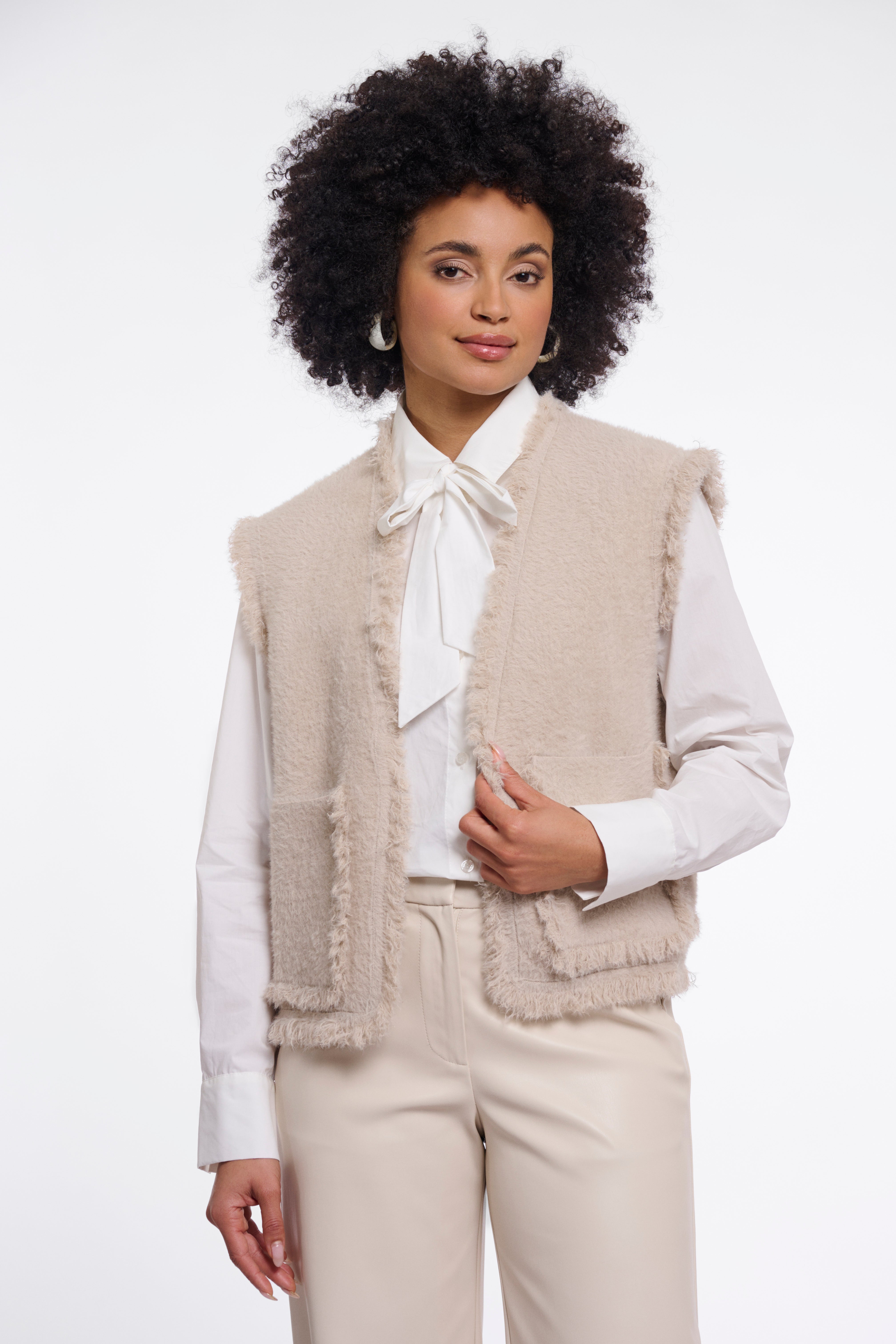 Kuschelige Eleganz: Die Bouclé-Strickweste mit Fransen-Details