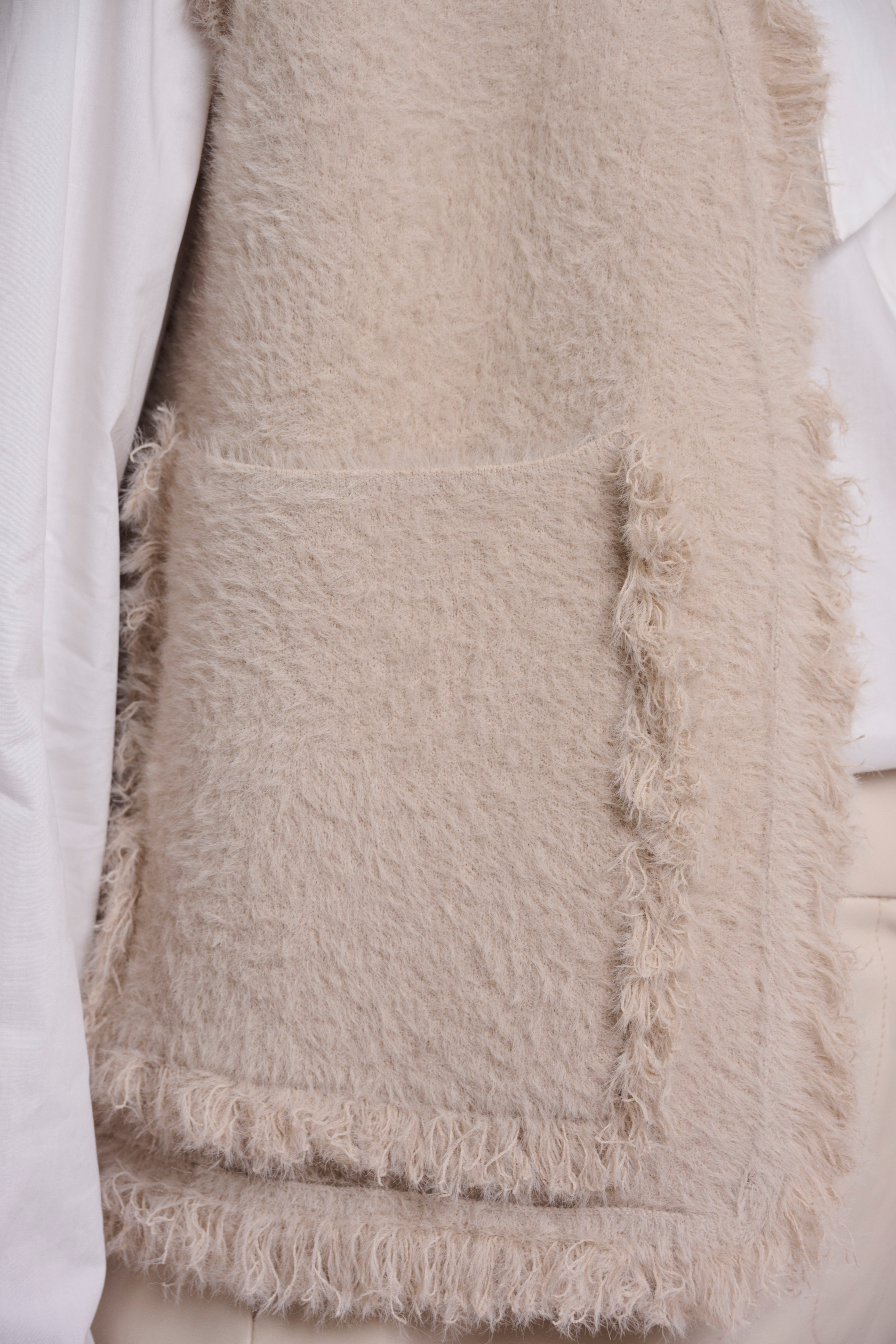 Kuschelige Eleganz: Die Bouclé-Strickweste mit Fransen-Details